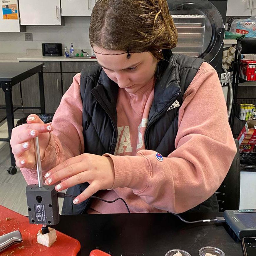 CTE Student using a Vernier Dual Range Force sensor to test meat tenderness. (Featured Image)