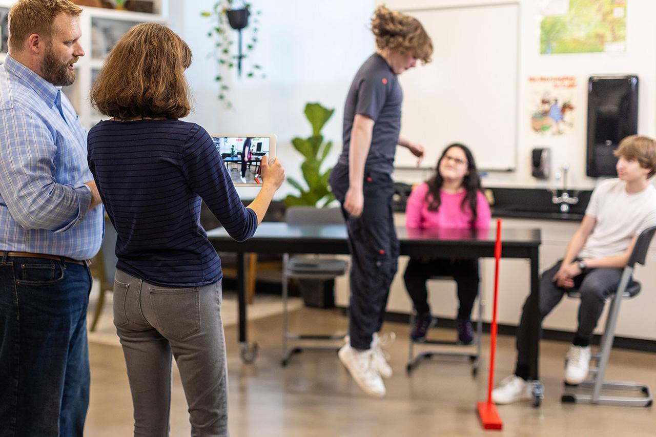 Students jump while a teacher captures their motion to later analyze using Vernier Video Analysis