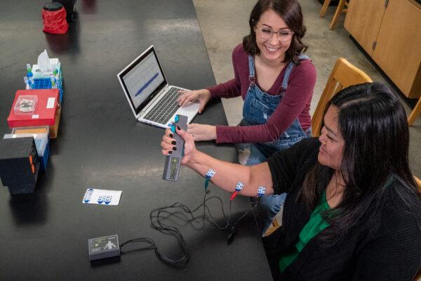 Two students collect data to investigate EMG with a Go Direct EKG and a Go Direct Hand Dynamometer