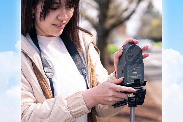 illustration of graphic clouds around a student using the Go Direct Air Quality sensor near the side of a road.